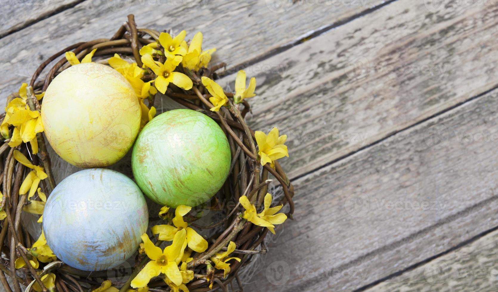 bo med färgade ägg med blommor på trästruktur. kopiera utrymme för din påsktext foto