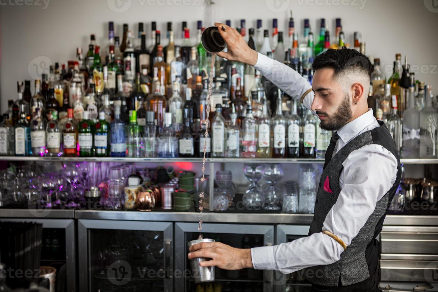 skicklig barman med shaker förbereder cocktail foto