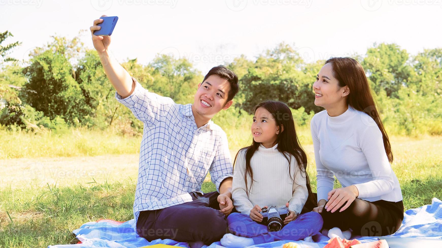 asiatisk kaukasisk familj tar selfie med föräldrar far mor dotter på semester till leenden i gerden så glad känsla med familj av semester gemenskap glädje relation livsstil asiater människor foto