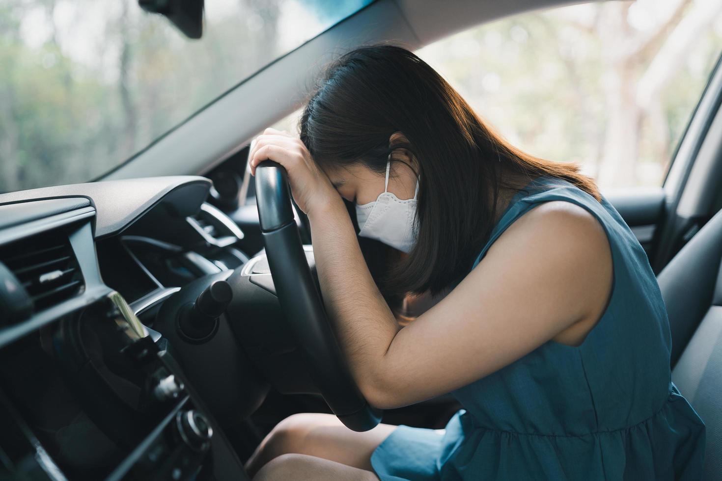 asiatisk kvinna som sover i sin bil på grund av trötthet från arbetsbelastning eller känsla av sömnighet. kvinna förare känner sig sömnig eller yr när hon kör hon sover i en bil. transport koncept. foto