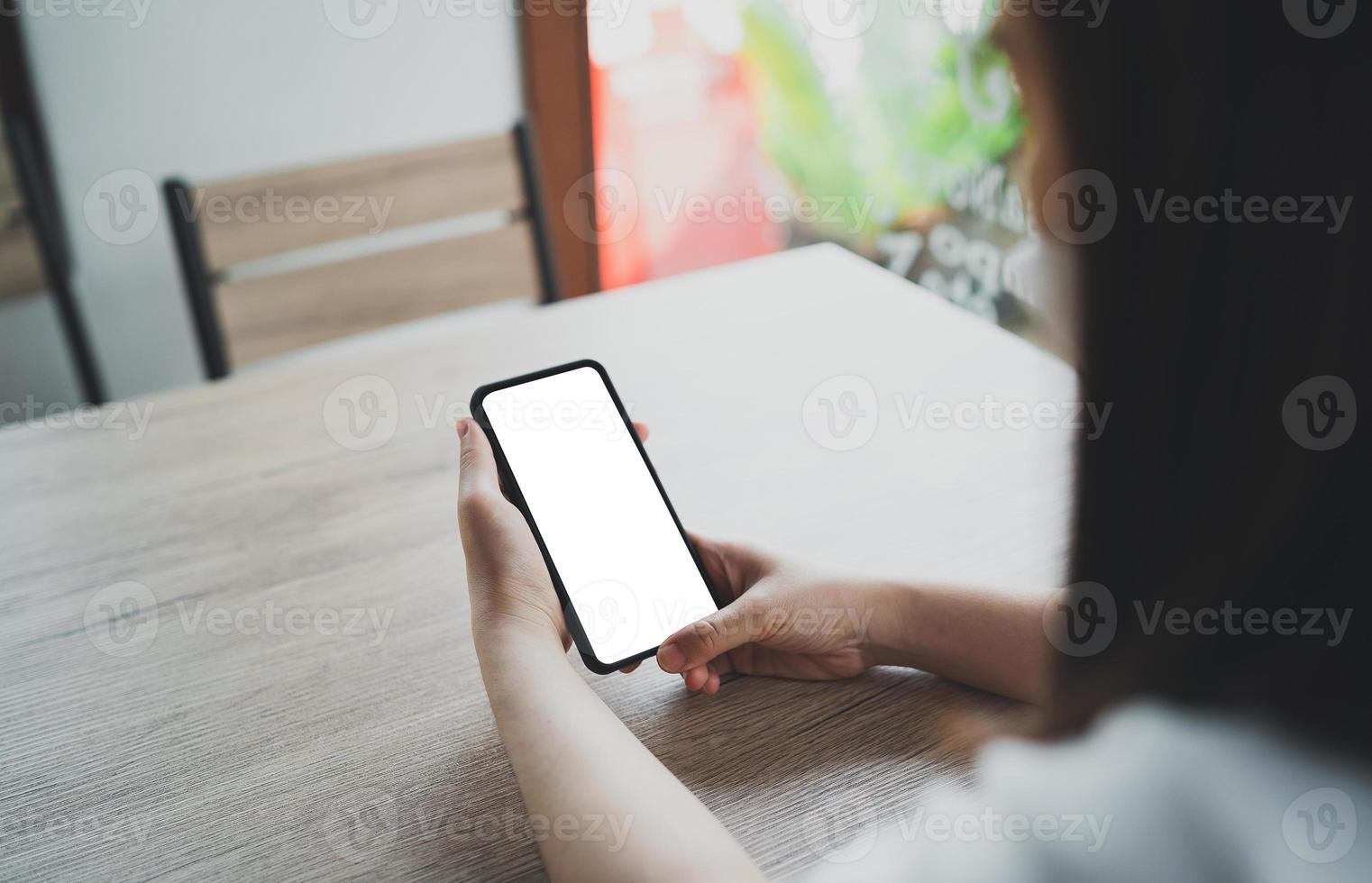 asiatisk kvinna håller mobiltelefon text eller meddelande. affärskvinna använder modern smartphone för att surfa på webben, läsa e-bok, handla aktier. foto