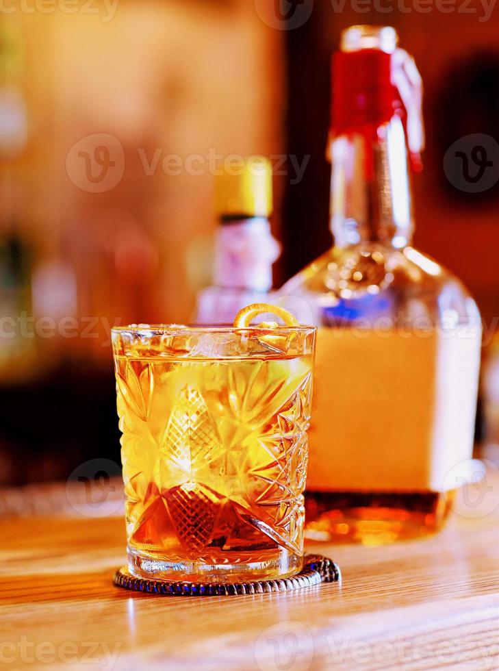 gammaldags cocktail, apelsin, flaskor och bägare på bardisken foto