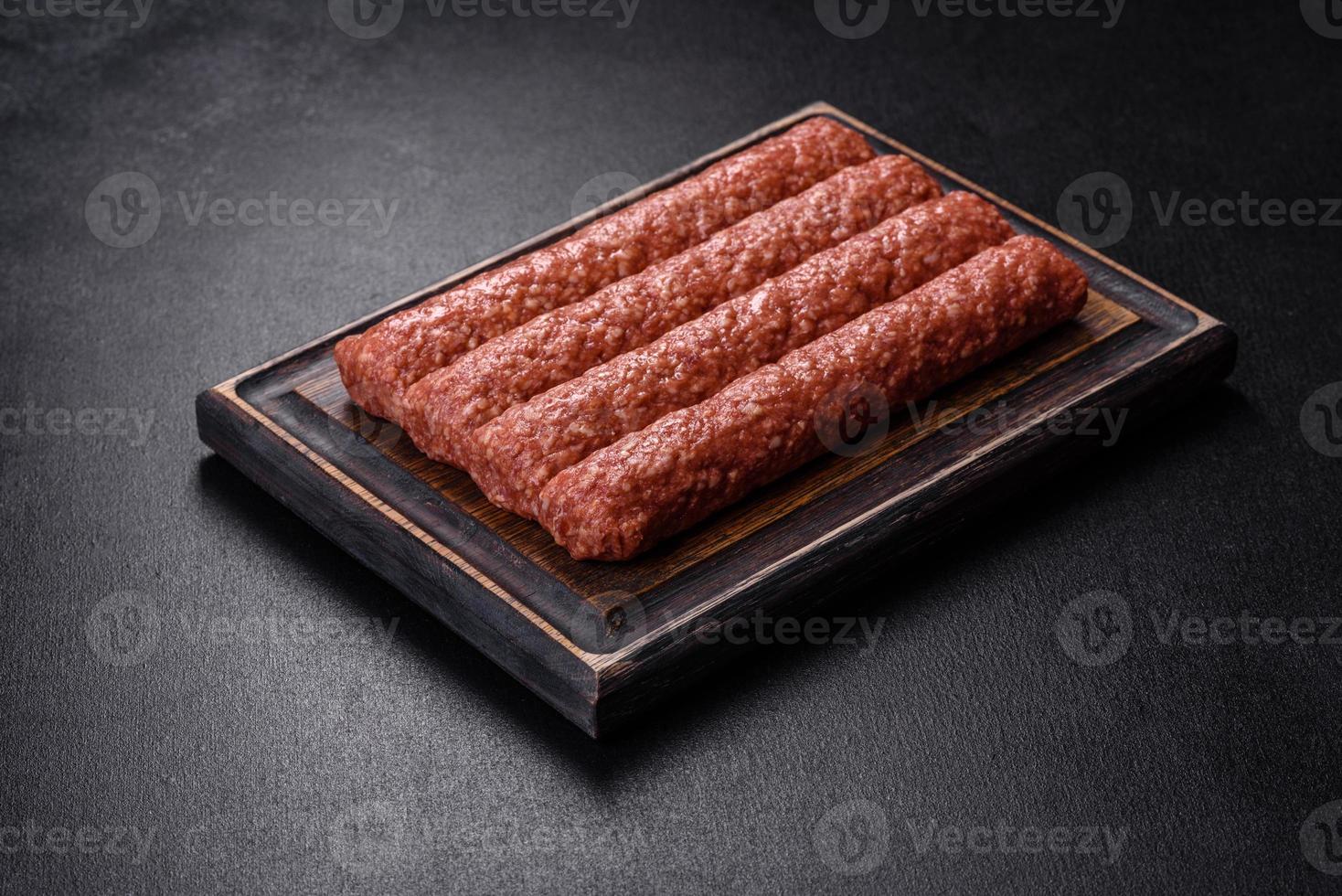 färsk råfärs för grillad kebab med kryddor och örter på en mörk betongbakgrund foto