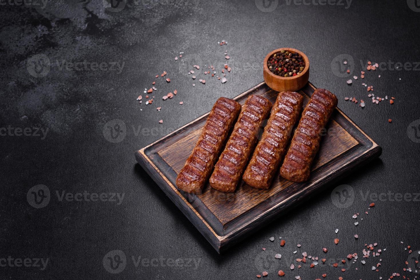 grillad kebab med kryddor och örter på en mörk betongbakgrund foto
