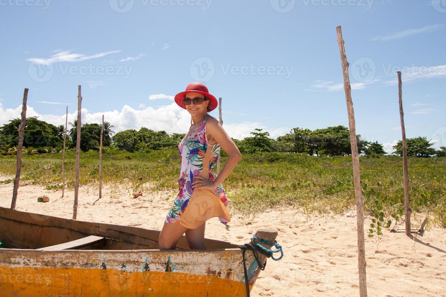 dam som står i en gammal träfiskebåt och njuter nära stranden i Corumbau, Bahia, Brasilien foto