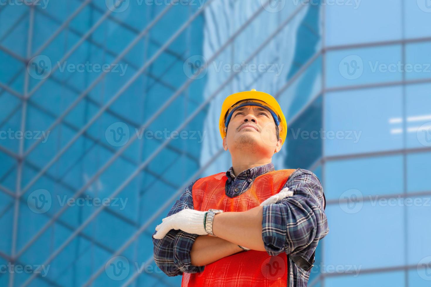 ingenjör man med urklippsbana kontroll och planeringsprojekt på byggarbetsplatsen, man tittar in i himlen foto