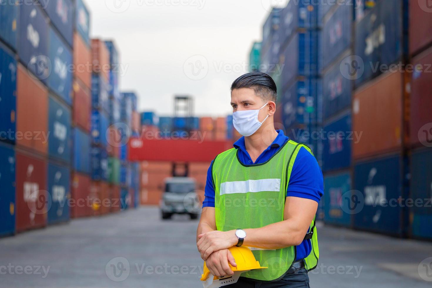 glad fabriksarbetare man håller hård hatt och ser fram emot, lycka ingenjör på containrar last koncept foto