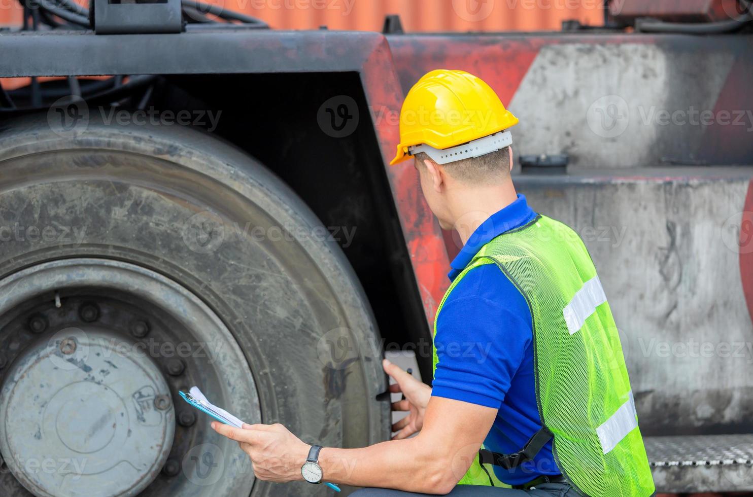 mekaniker som kontrollerar hjul i lastcontainer. professionell tekniker förkontrollera gaffeltruckdäck, säkerhetskoncept. foto