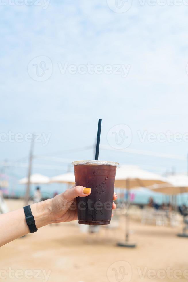 hand som håller iced americano kaffe foto