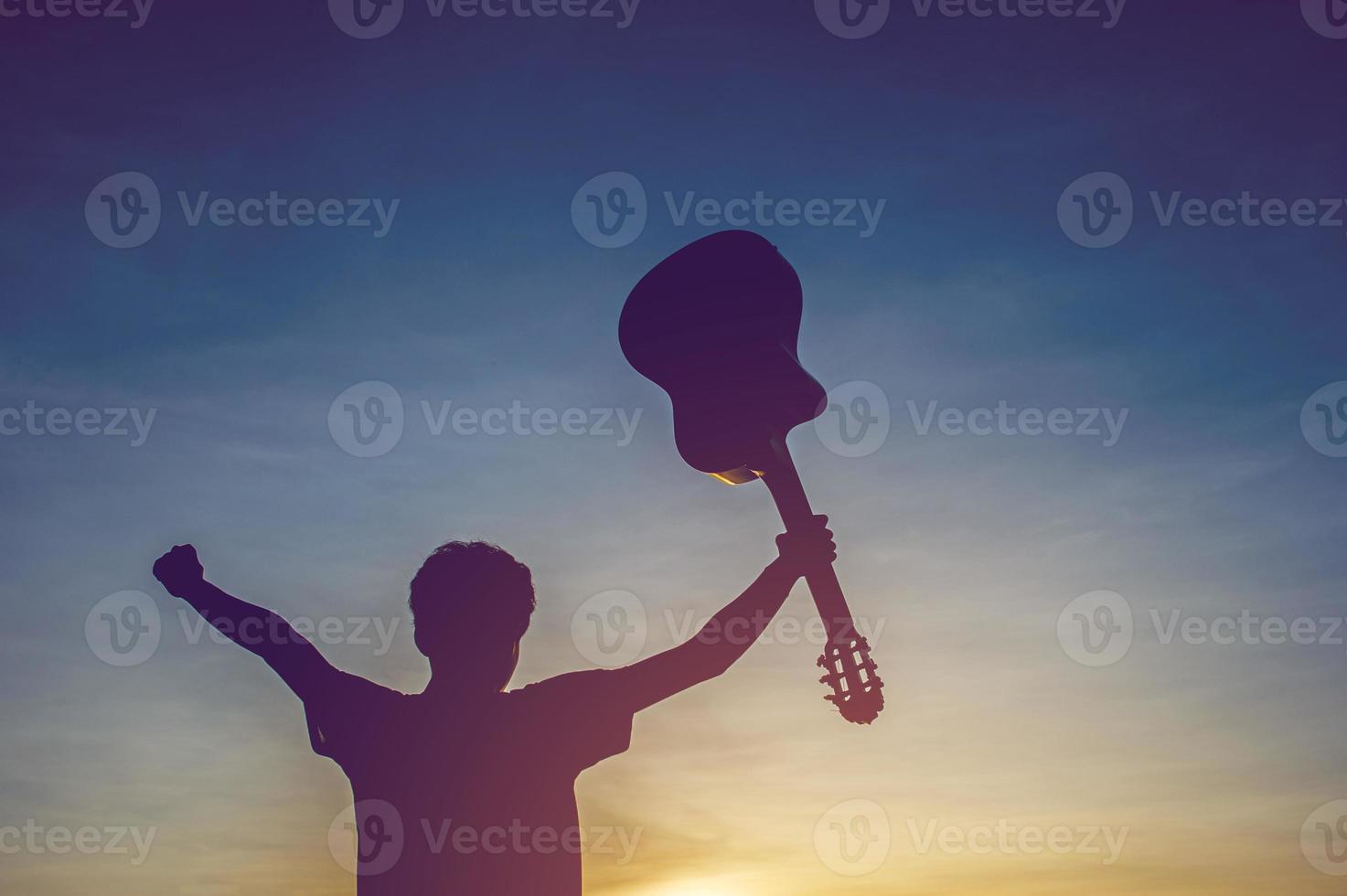silhuett av en gitarrist i skuggorna vid solnedgången ljus, siluett koncept. foto