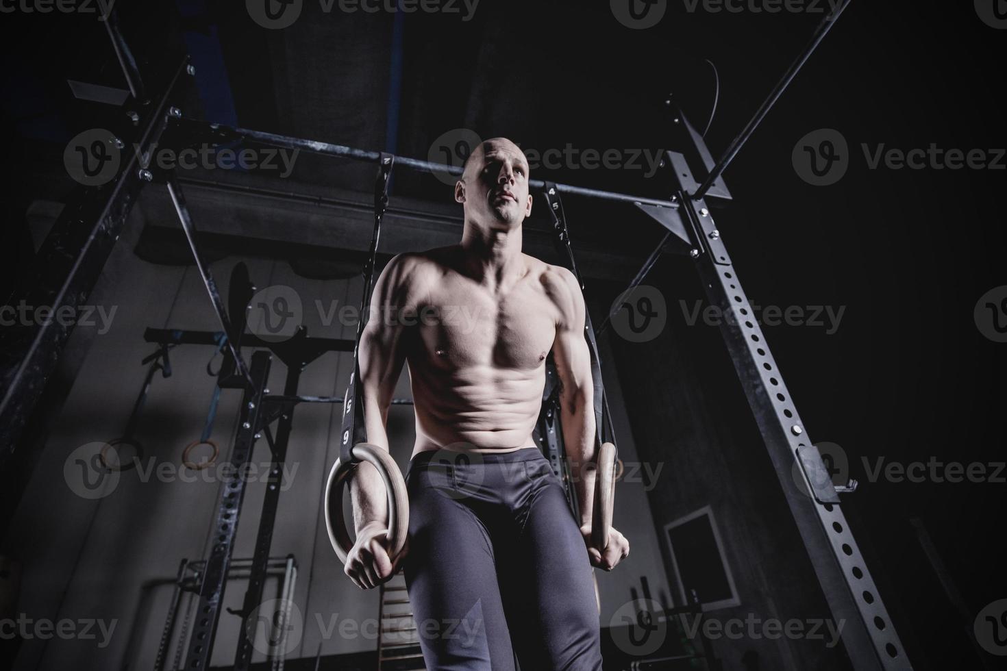 muskel-upp övning man gör cross fit workout på gymmet på gymnastiska ringar foto