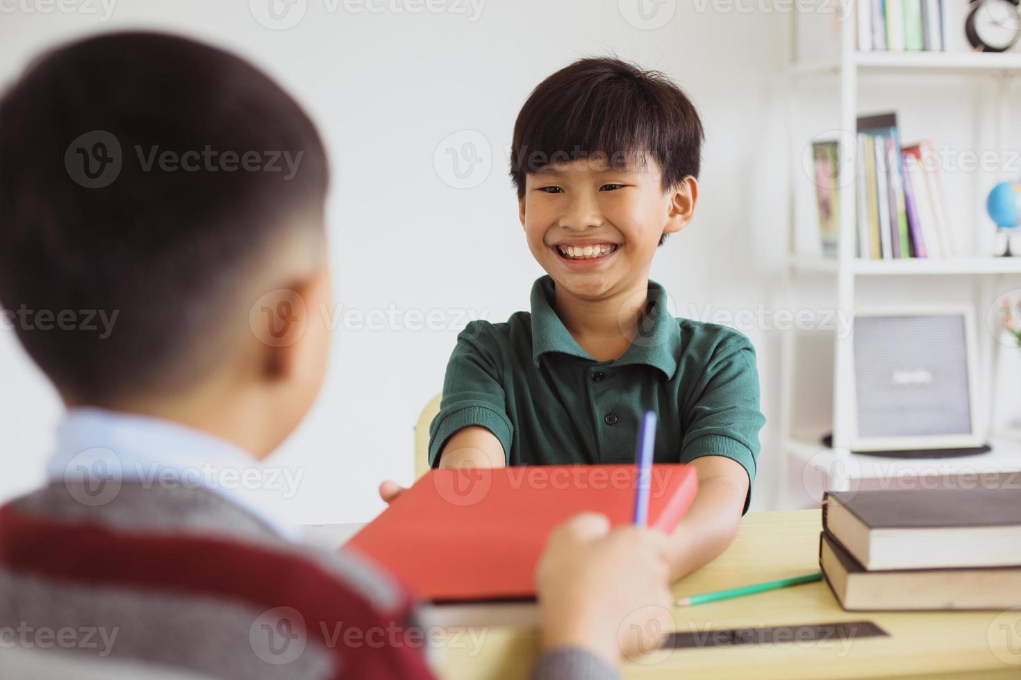 glad asiatisk skolpojke interagerade i klassrummet foto