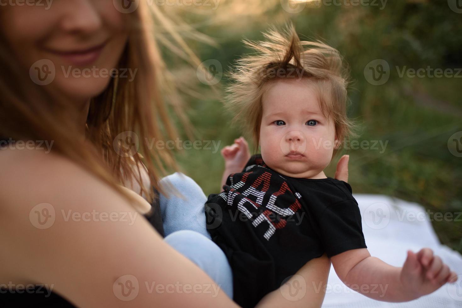 ung mamma kramar söt baby utomhus foto