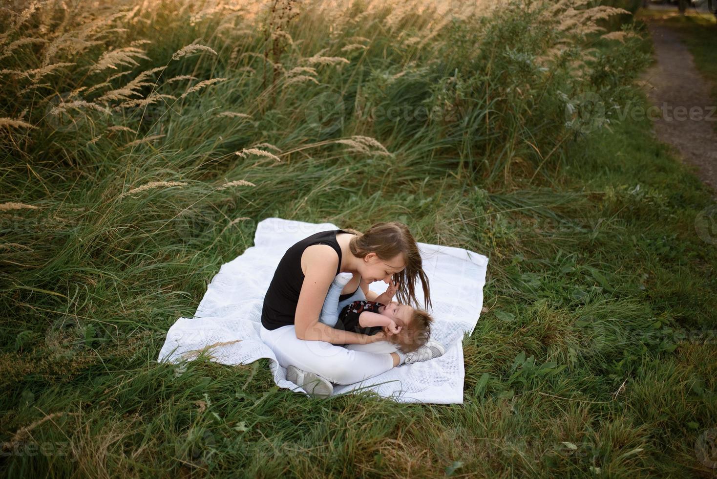 mamma och bebis myser på en pläd foto