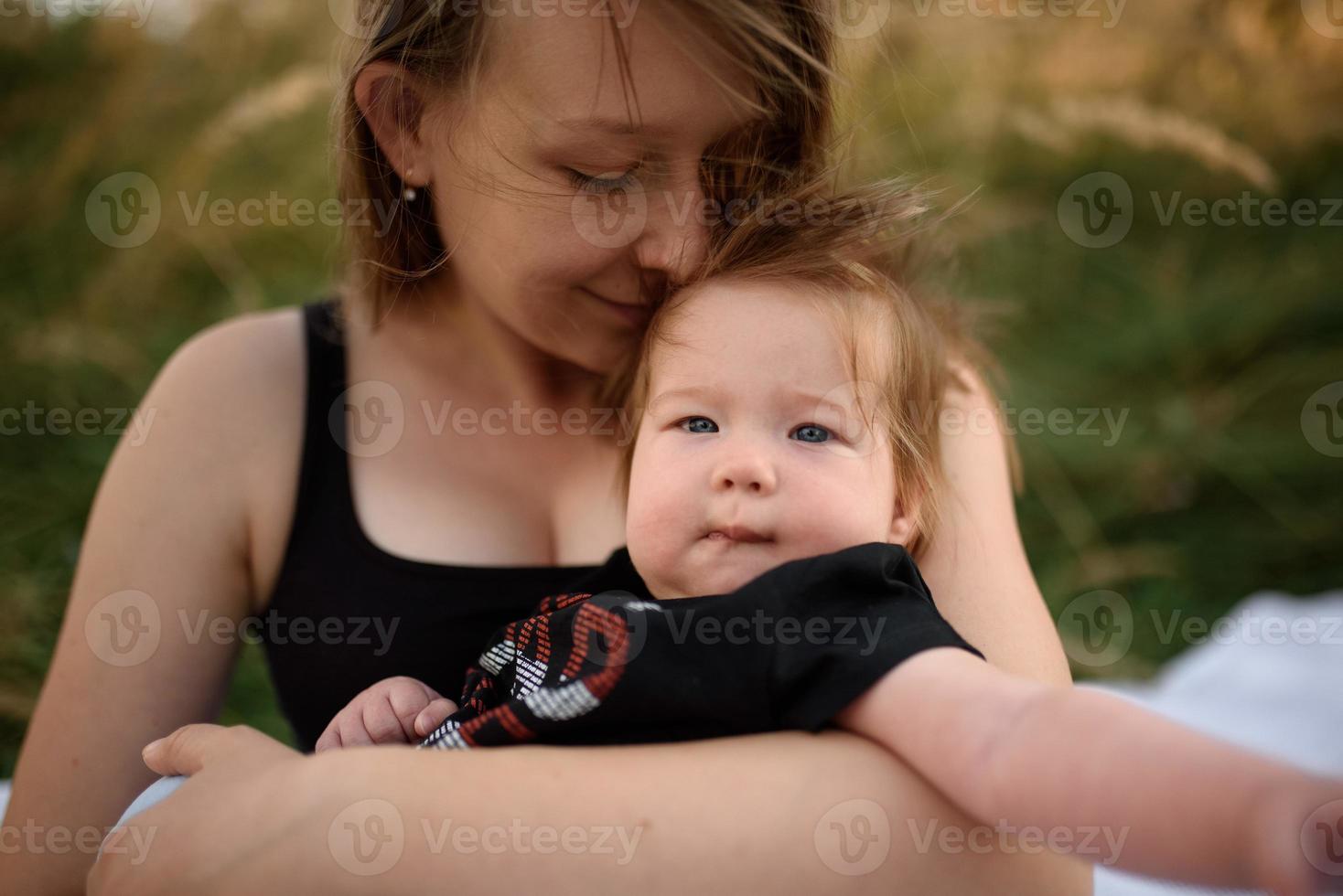 ung mamma kramar söt baby utomhus foto