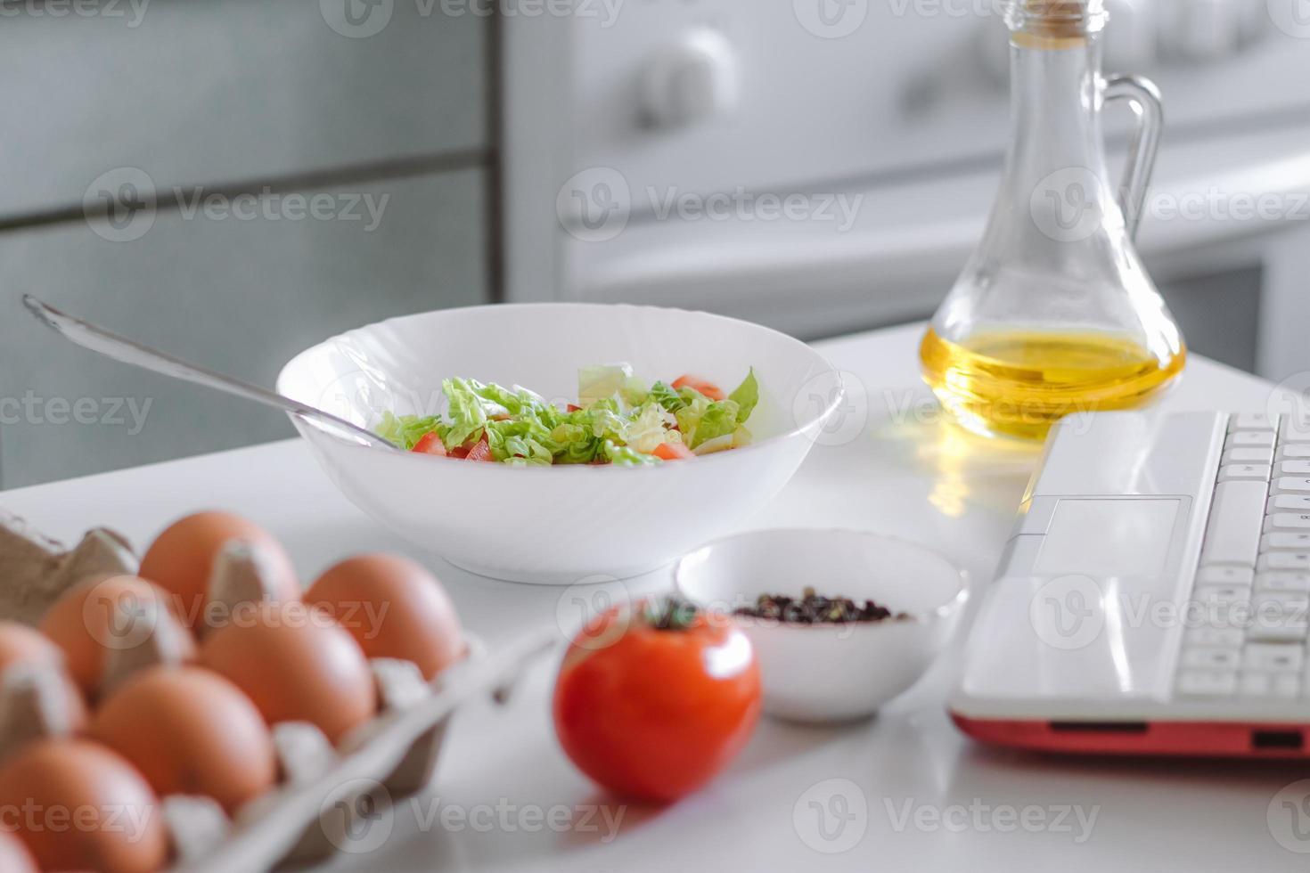 matlagning online. förbereda sallad med hjälp av digital kokbok. foto