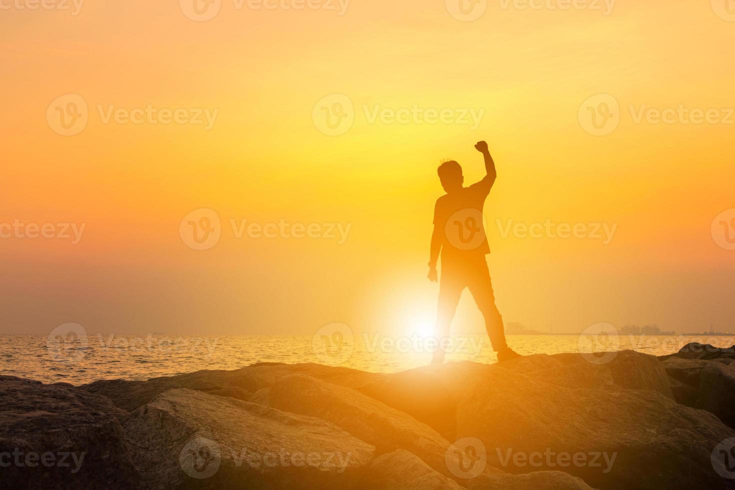 silhuett av man med urklippsbana firande framgång lycka på en sten kväll himmel solnedgång bakgrund, sport och aktivt liv koncept. foto