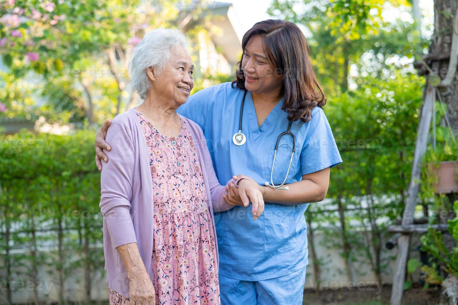 läkarehjälp och vård asiatisk äldre eller äldre gammal damkvinna använder rullator med stark hälsa när man går på park i glad ny semester. foto
