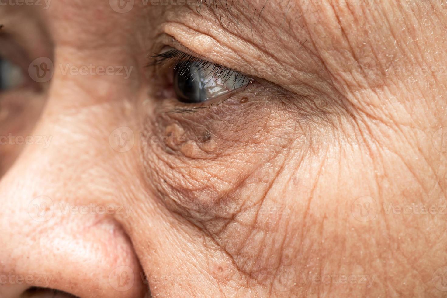 asiatisk äldre kvinna ansikte och öga med rynkor, porträtt närbild. foto