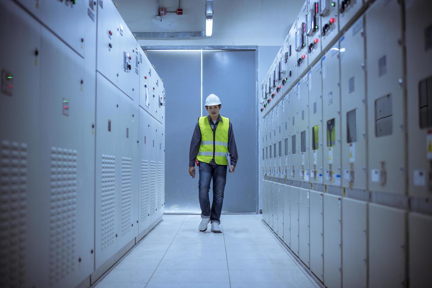 ingenjör kontrollerar och inspekterar på mdb-panelen. De arbetar med elcentralen för att kontrollera spänningsomfånget som fungerar i huvudfördelningscentralerna fabriken. foto