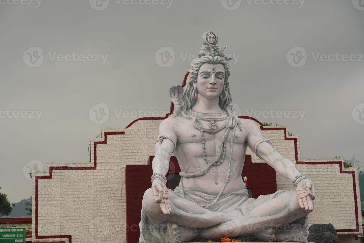 hinduisk gud shiva skulptur sitter i meditation på ganges floden i rishikesh, Indien, foto