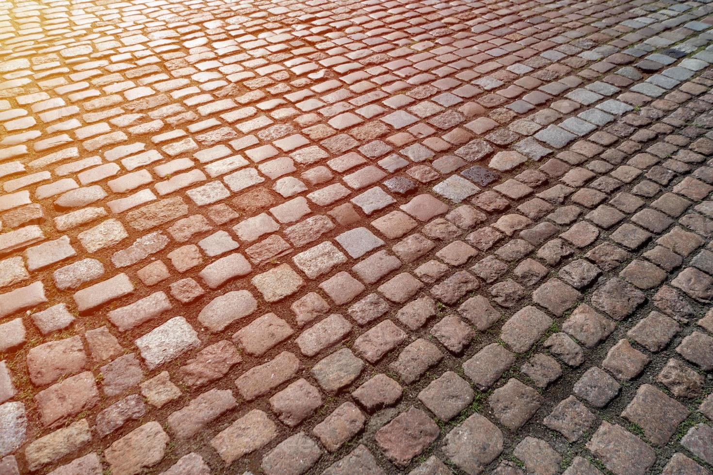 kakel textur. mönster av antiktysk kullersten i stadens centrum. små gatstenar i granit. antikgrå trottoarer. foto