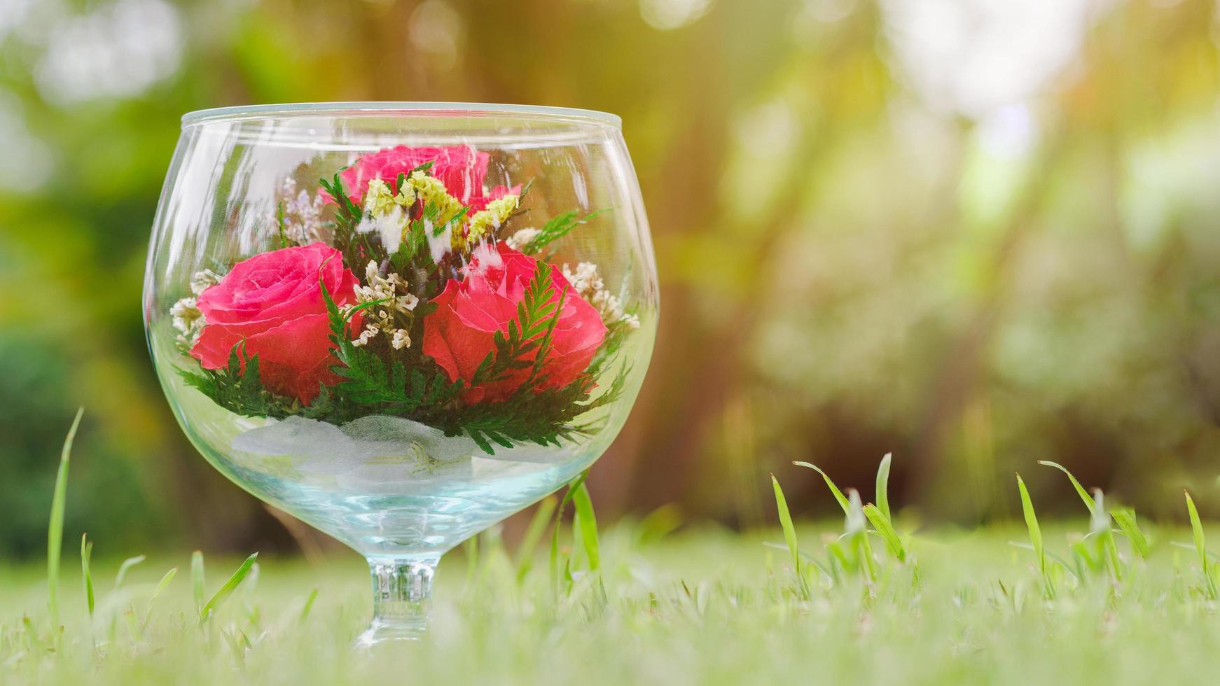 kristall vinglas är stora, dekorerade med en röd ros på ängen med vacker belysning mässa. kopiera utrymme. presentidéer för älskare. foto