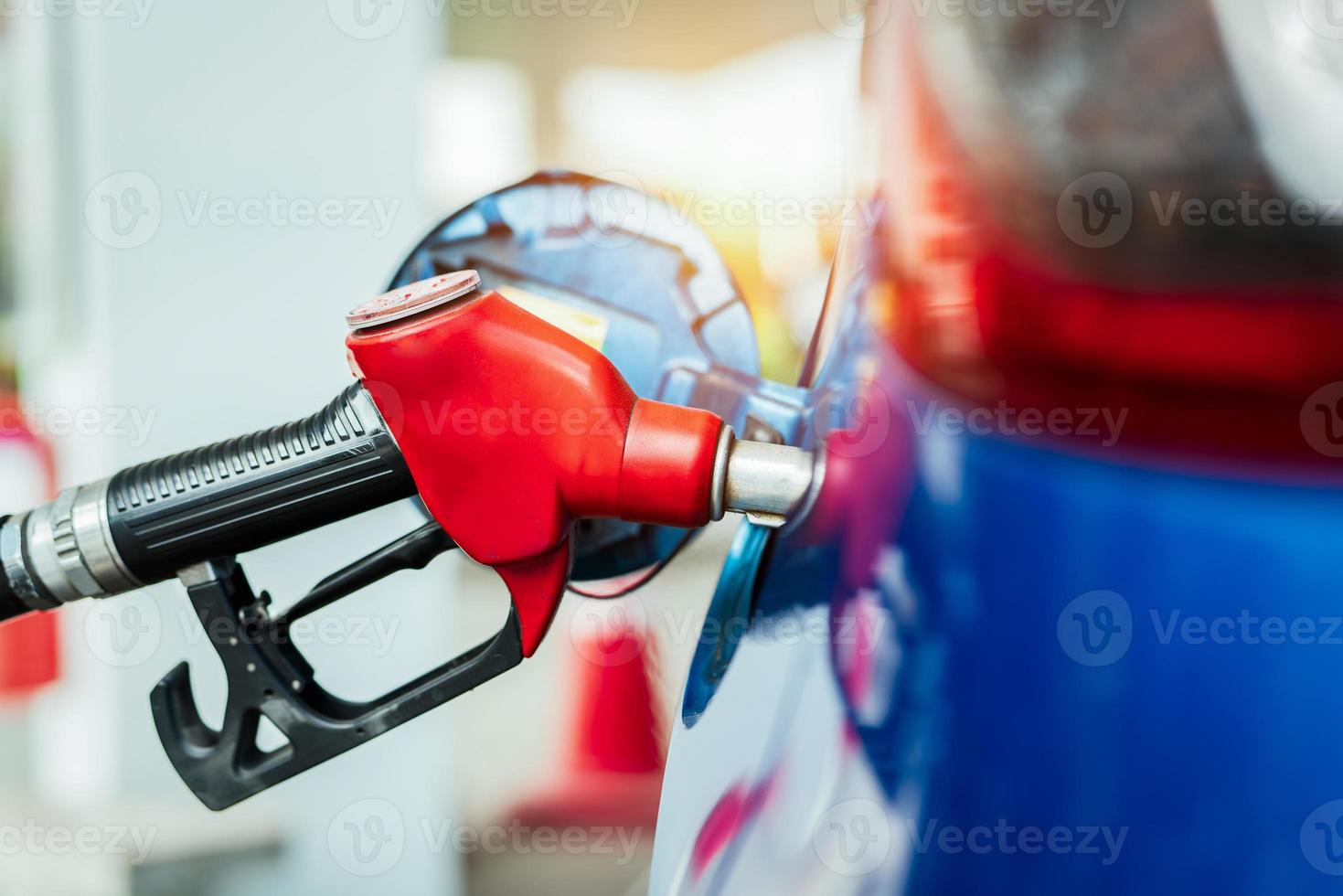 biltankning på bensinstationen. tanka på med bensin bensin. bensinpump som fyller bränslemunstycke i bränsletanken på bilen på bensinstationen. bensinindustri och service. bensinpris och oljekris koncept. foto