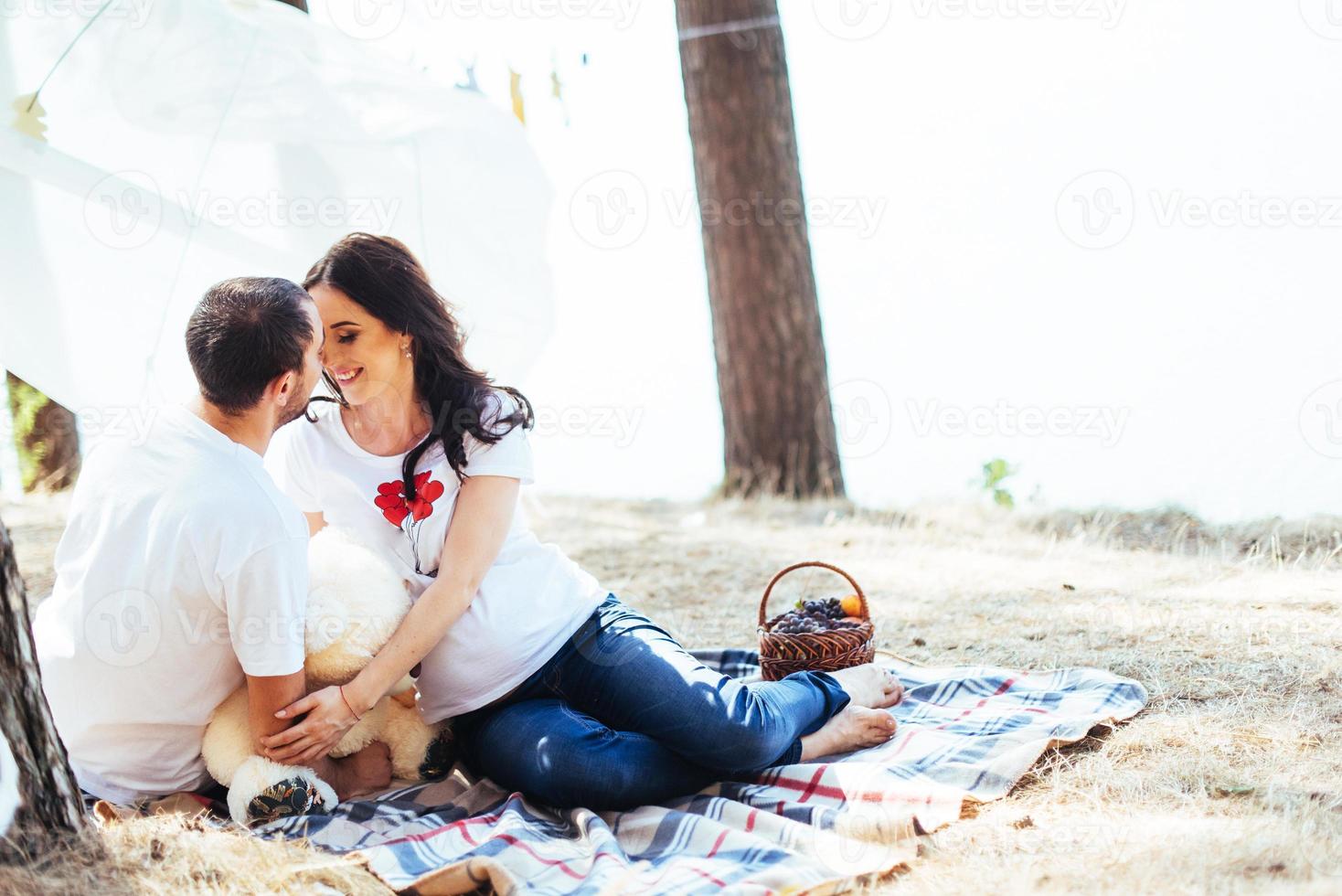 gravid kvinna med sin man på en picknick. foto