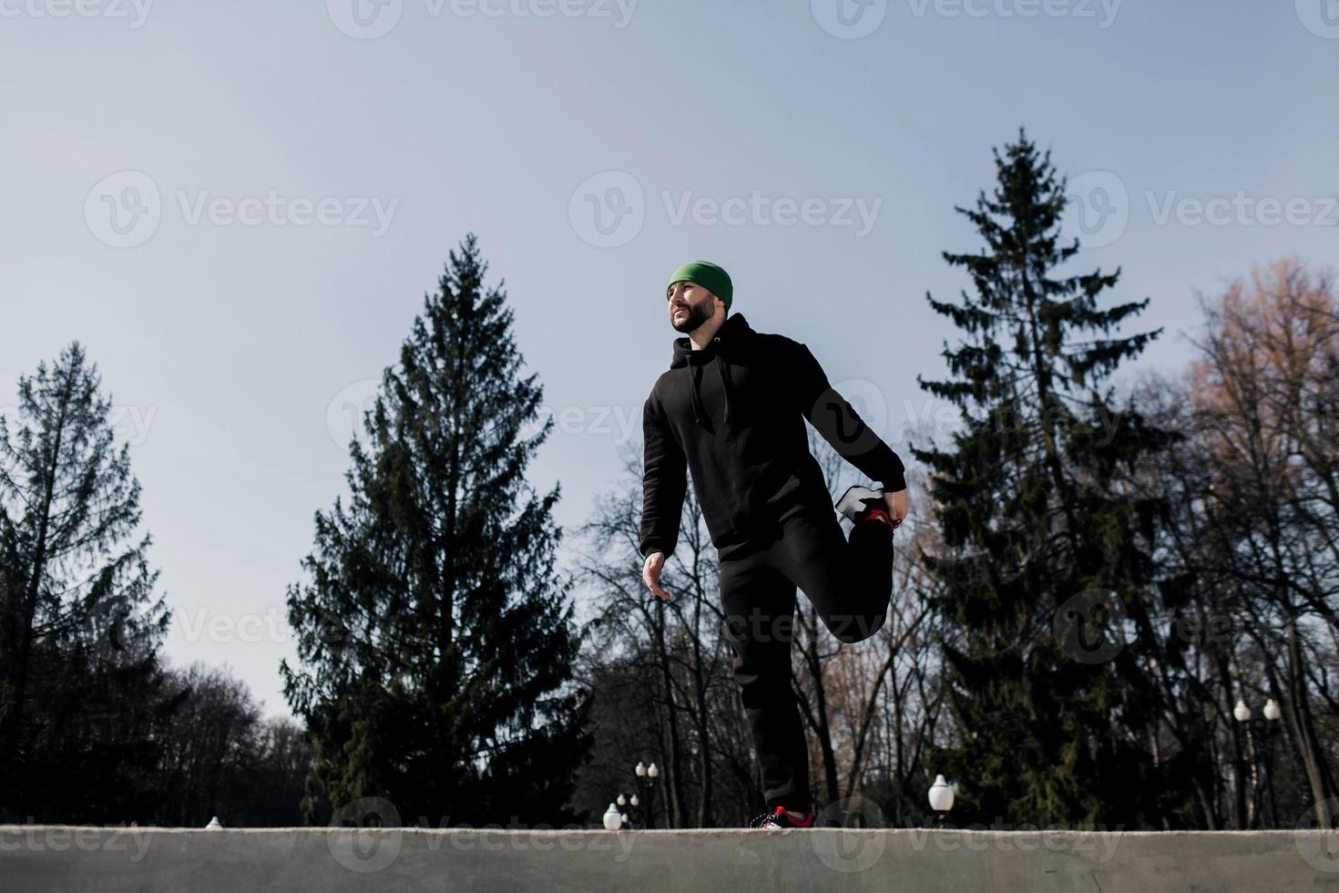 sport man sträcker benet tillbaka foto