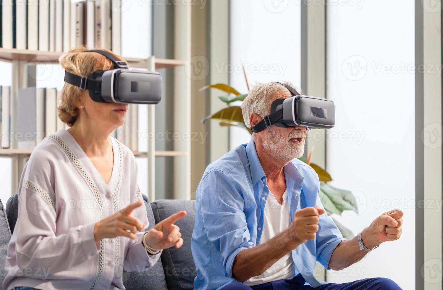 äldre mogna par som sitter på soffan och har kul med virtuell verklighetsglasögon, glada äldre teknikkoncept foto
