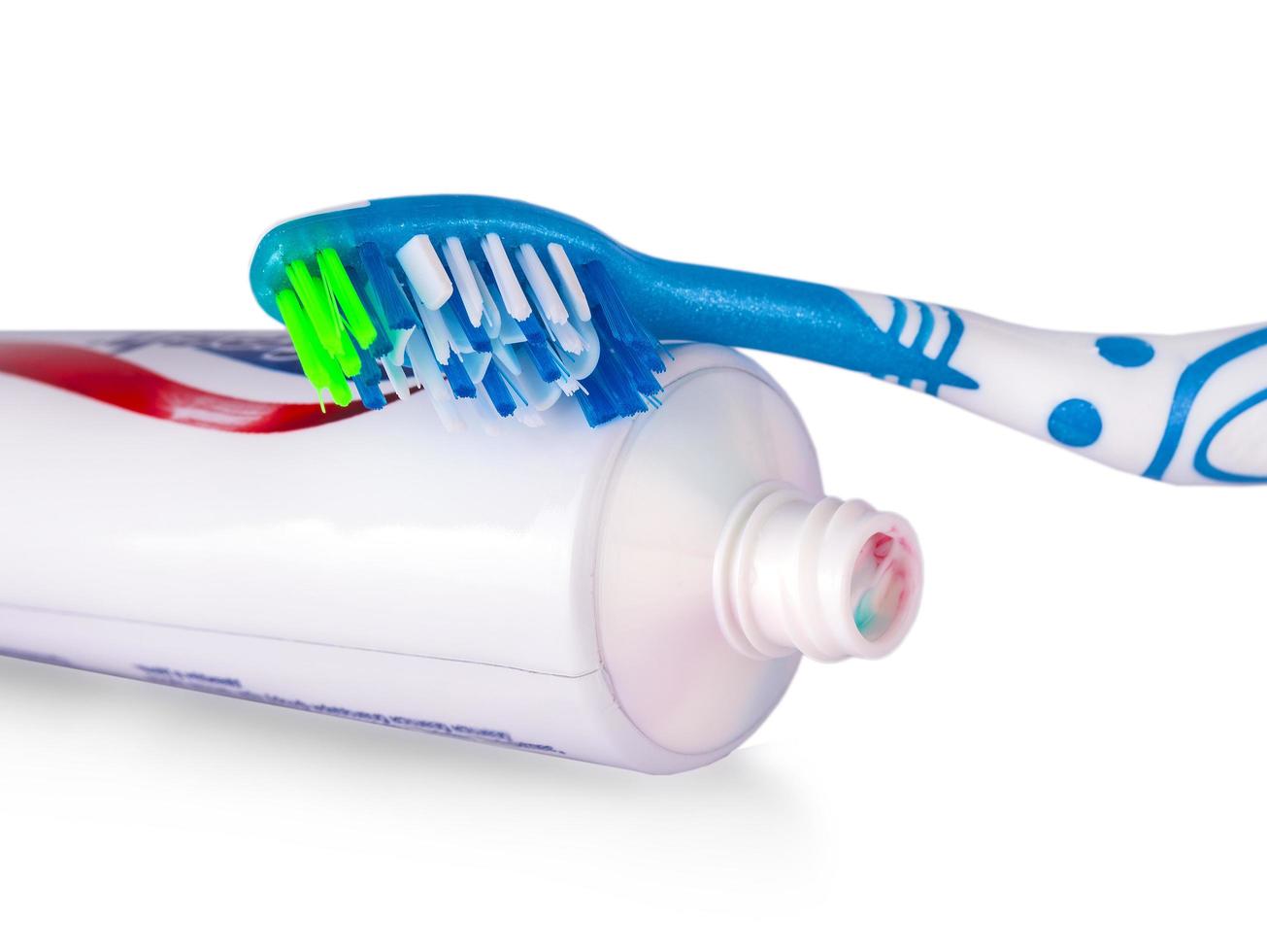 färgad tandborste med tandkräm på vit bakgrund foto
