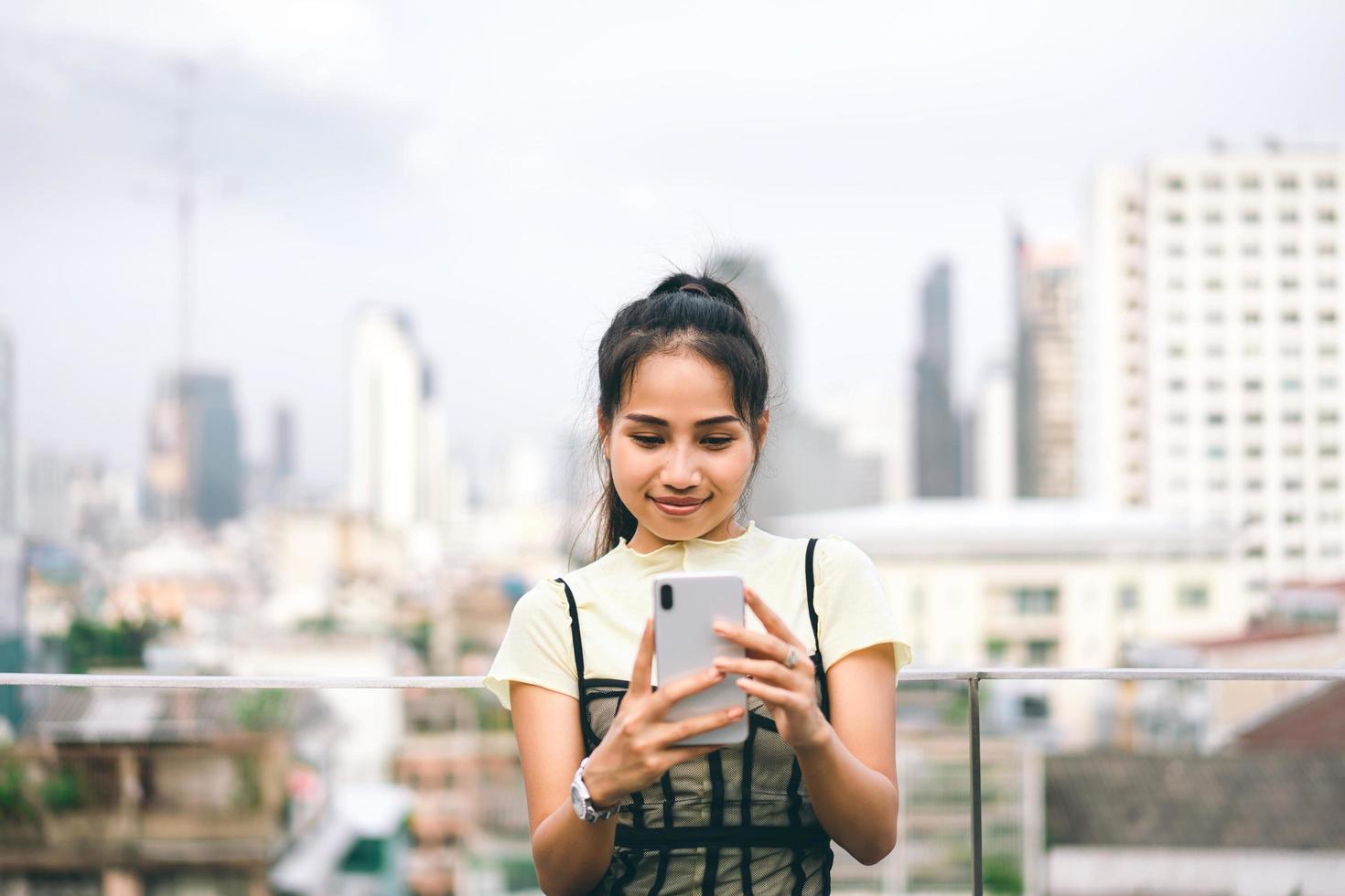 ung företag vuxen asiatisk kvinna som använder mobiltelefon för online dating app text och chatt oskärpa stadsbakgrund. foto