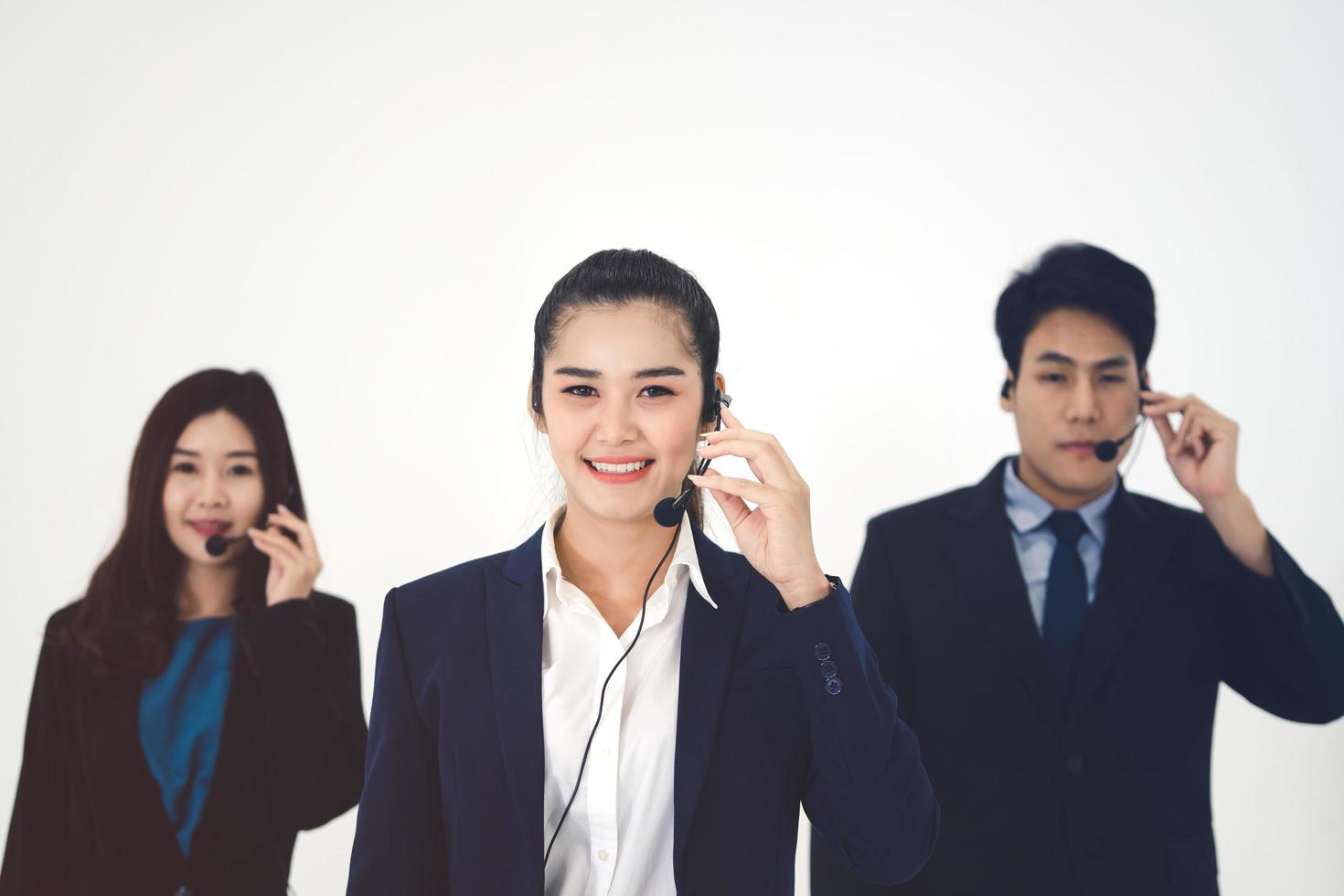 porträtt av positivt leende ung affärspersonal asiatiska call center team kvinna och man foto