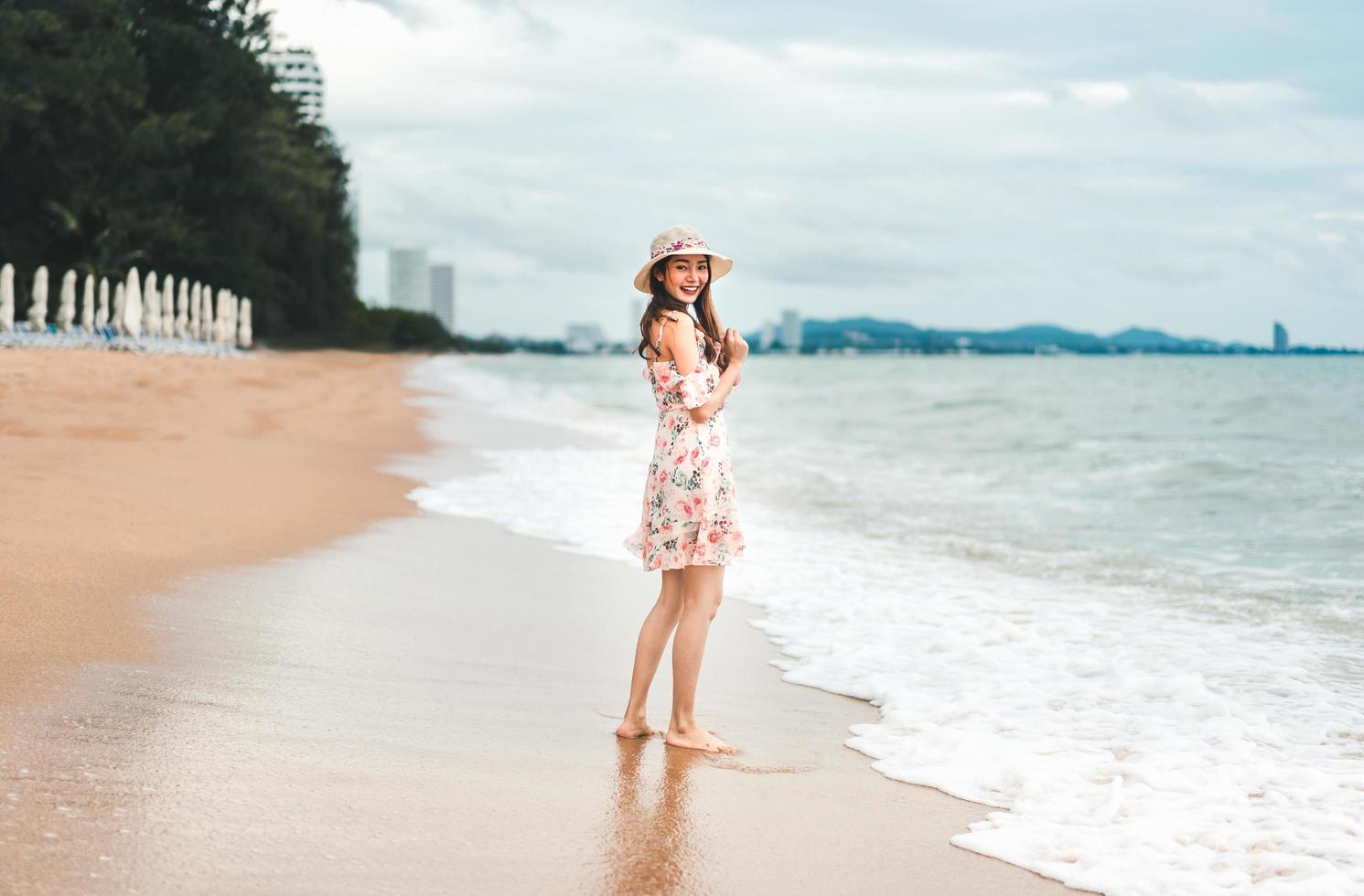 ung asiatisk kvinna koppla av på stranden foto