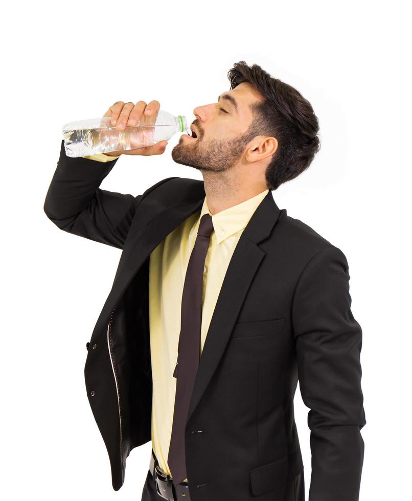 porträtt av ung man dricksvatten från flaska isolerad på vit bakgrund. foto