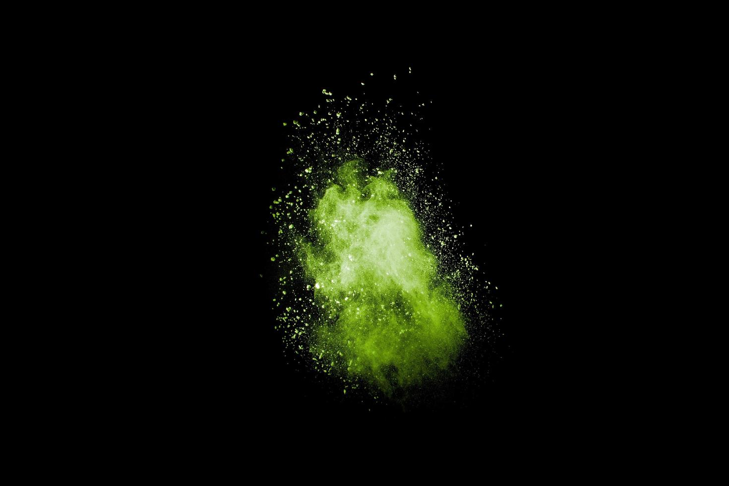 abstrakt grön dammexplosion på svart bakgrund. grönt pulver stänkte. foto