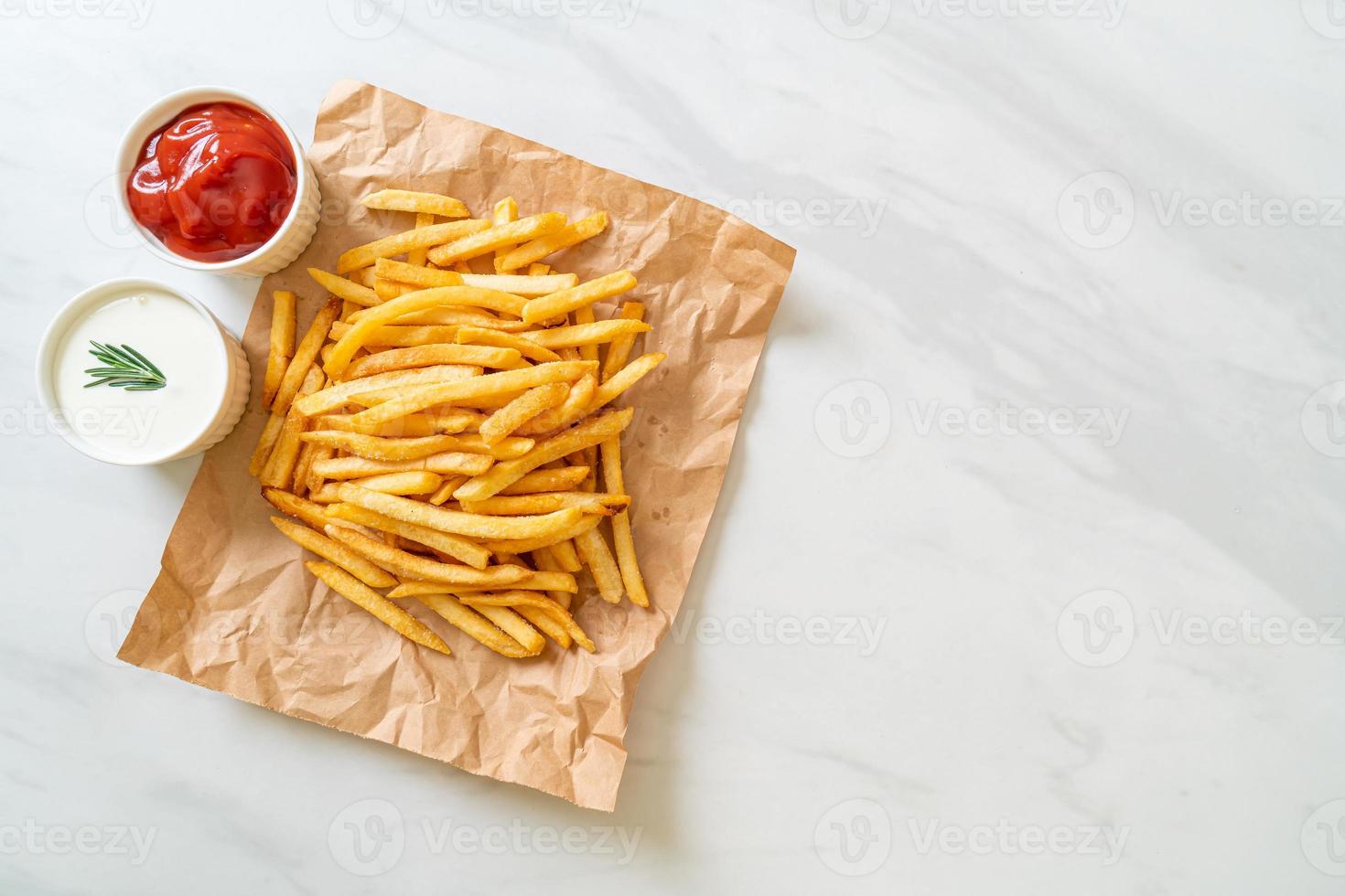 pommes frites med gräddfil och ketchup foto