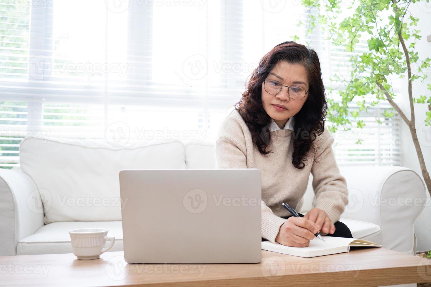 bild av senior asiatisk affärskvinna som arbetar hemma foto
