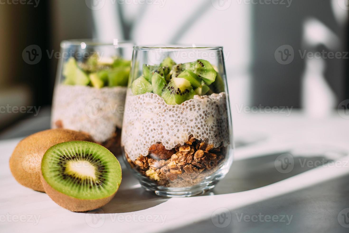 nyttig frukost. chiapudding med kiwi och granola i glas foto