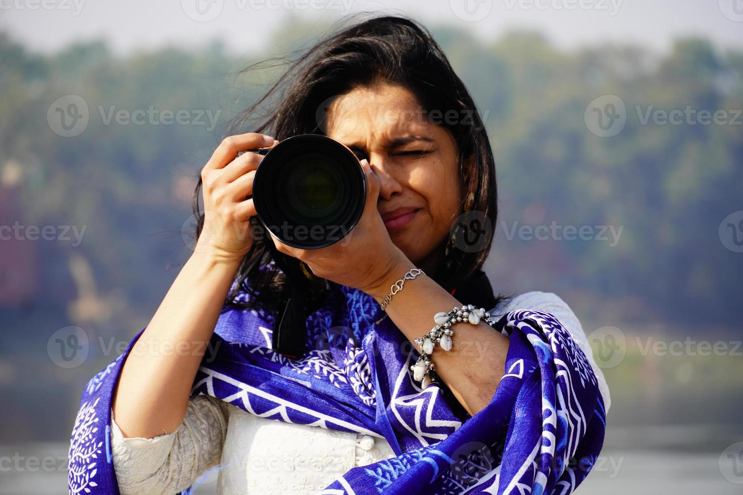kvinnlig fotograf bild porträtt av en fotograf som täcker hennes ansikte med kameran. foto