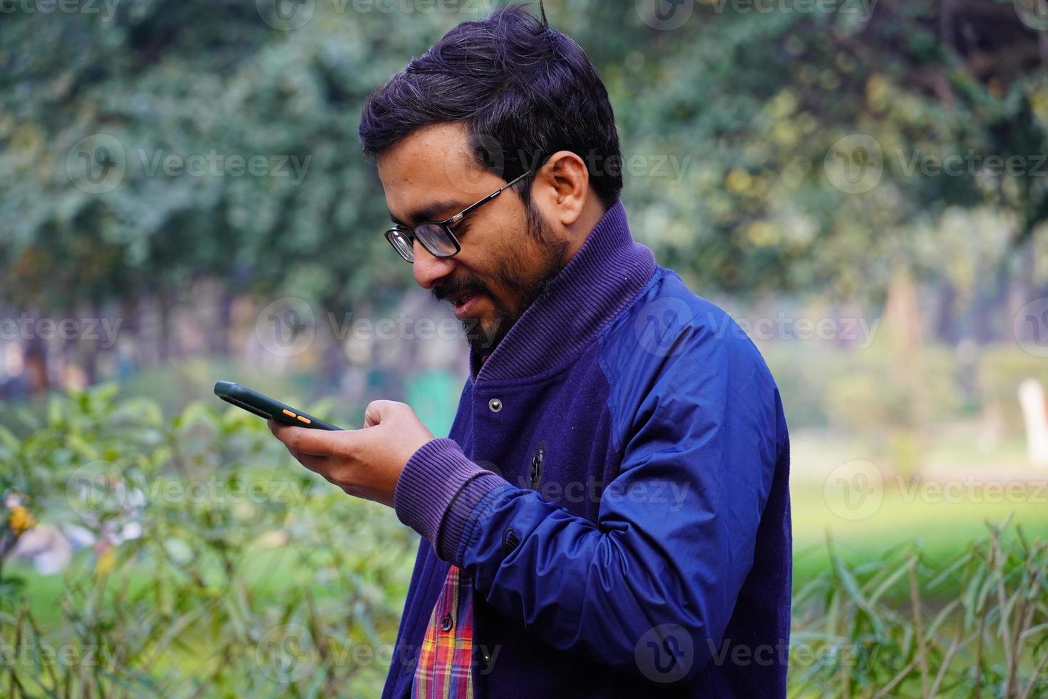indisk man använder mobil på morgonen foto