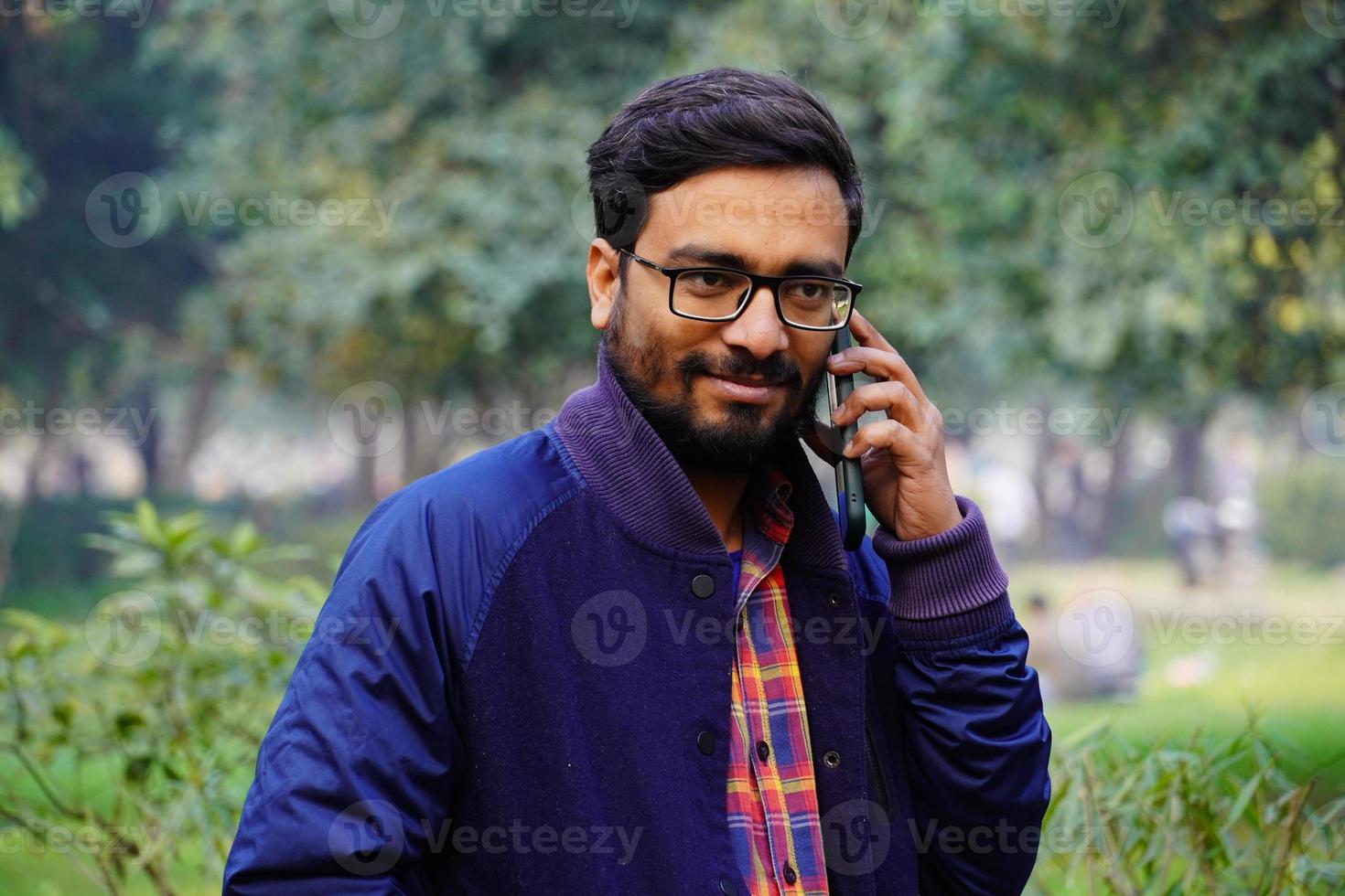vår indisk man pratar med sin telefon med någon foto