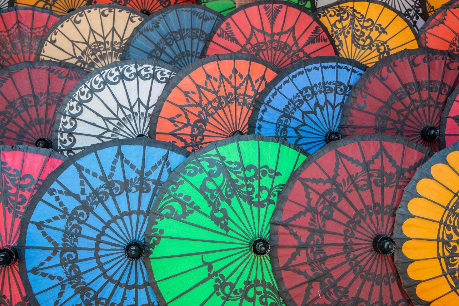 grupp färgglada myanmar parasoller säljer i souvenirbutik. Patein-parasollet för en är helt enkelt förtrollande, med sin vackra design som innehåller en sorts konstnärliga målningar. foto