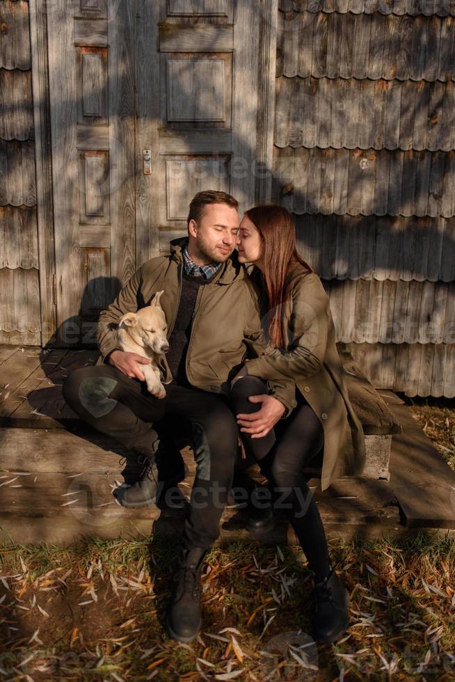 härligt par tillbringar höstdagen utomhus med sin hund foto
