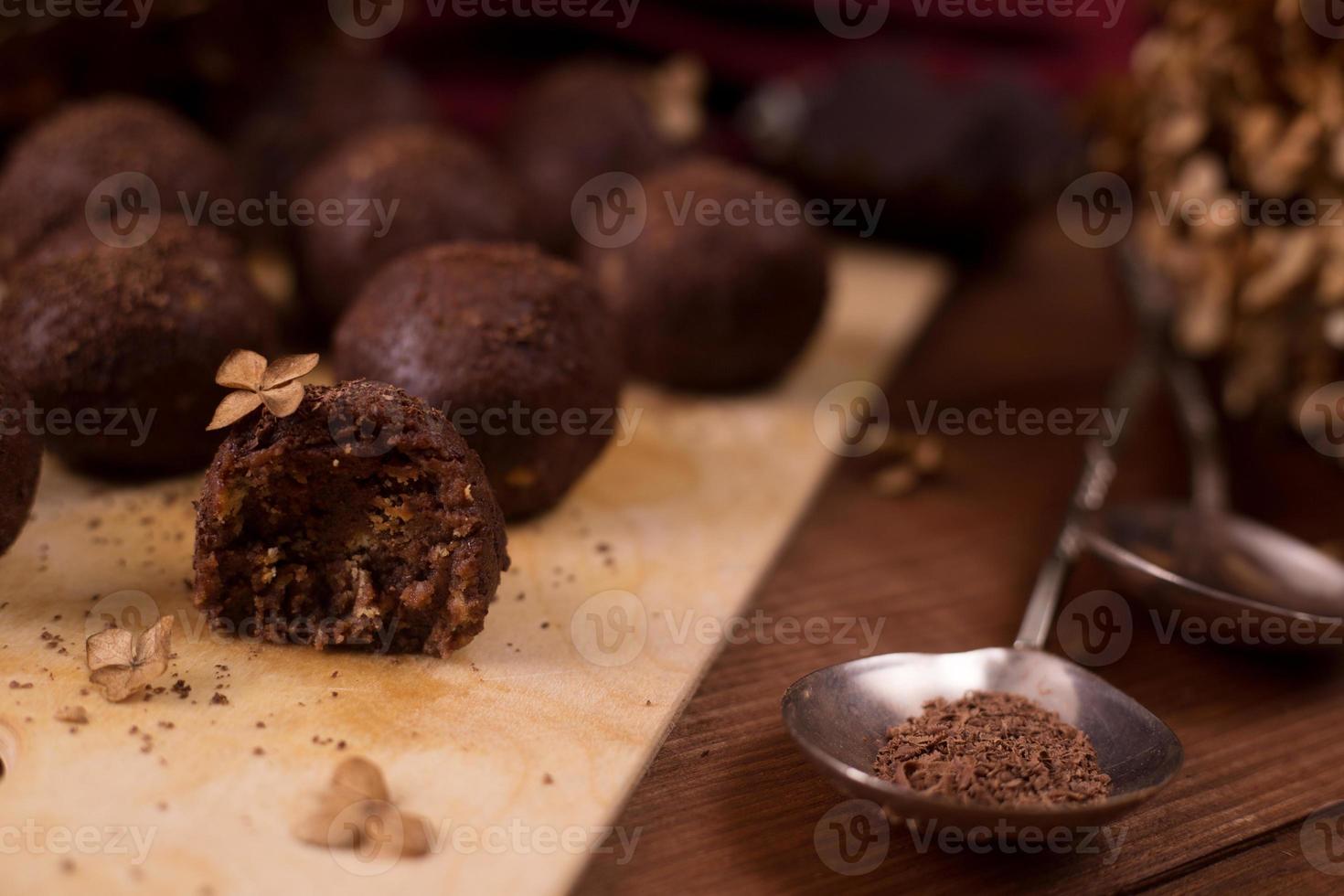 kakaobollar, chokladtryffelkakor ombord på träbakgrund foto