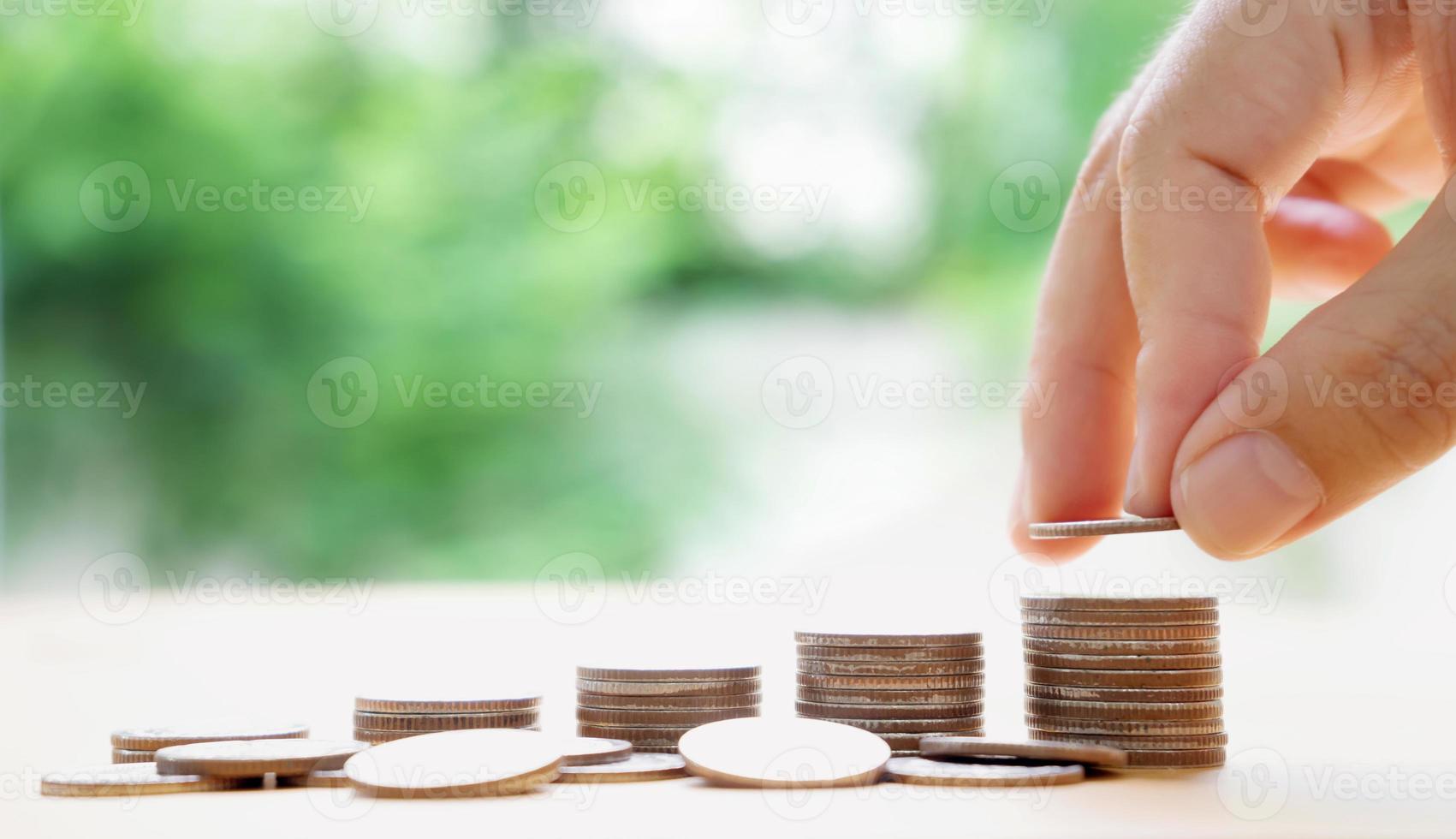 hand lägga pengar mynt till stapeln av mynt. pengar, finansiella, affärstillväxt koncept. foto