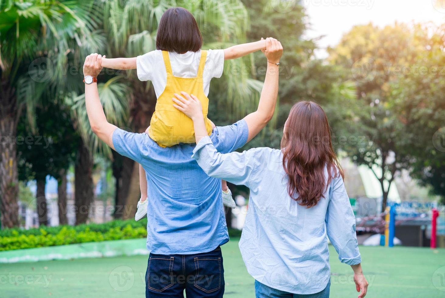 bild av ung asiatisk familj som spelar tillsammans i parken foto