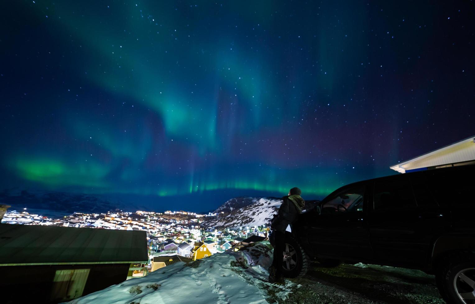 vackert norrsken över stadens stadsbild. norrsken i södra kitaa qaqortoq grönland foto