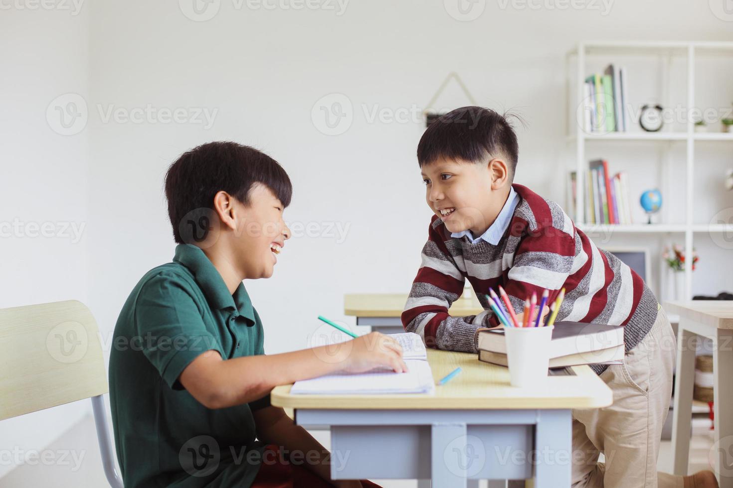 två glada elever som pratar och har roligt i en klass foto